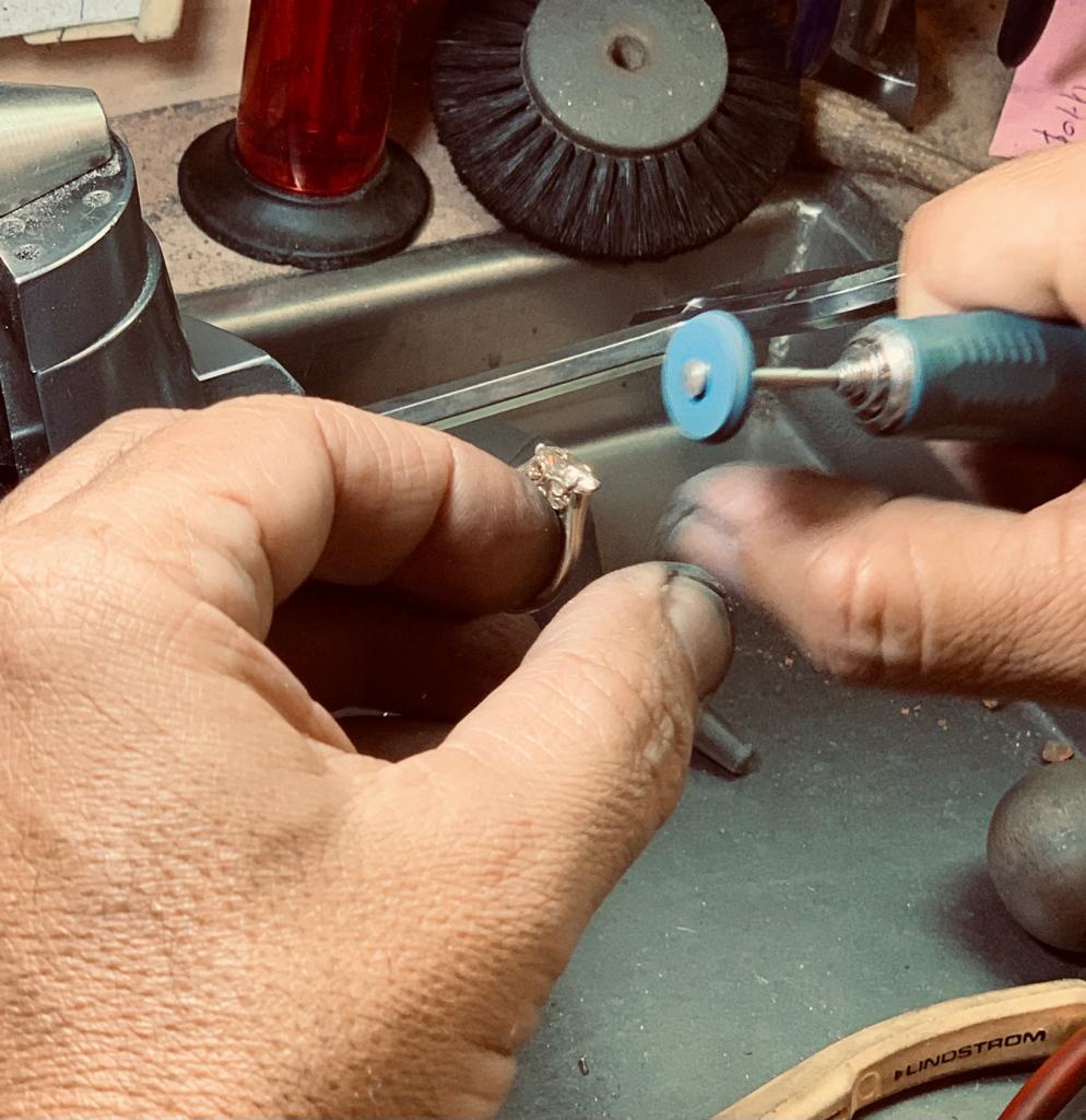 Jeweller polishing a diamond ring at the workbench