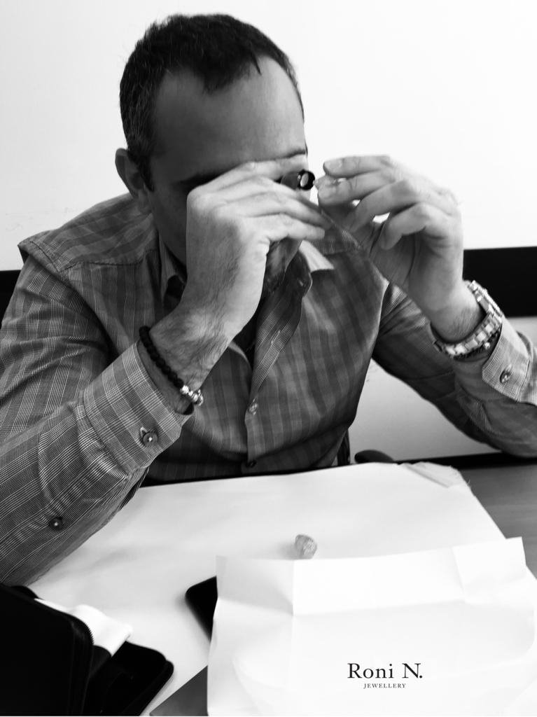 Diamond expert inspecting a rough stone with a loupe